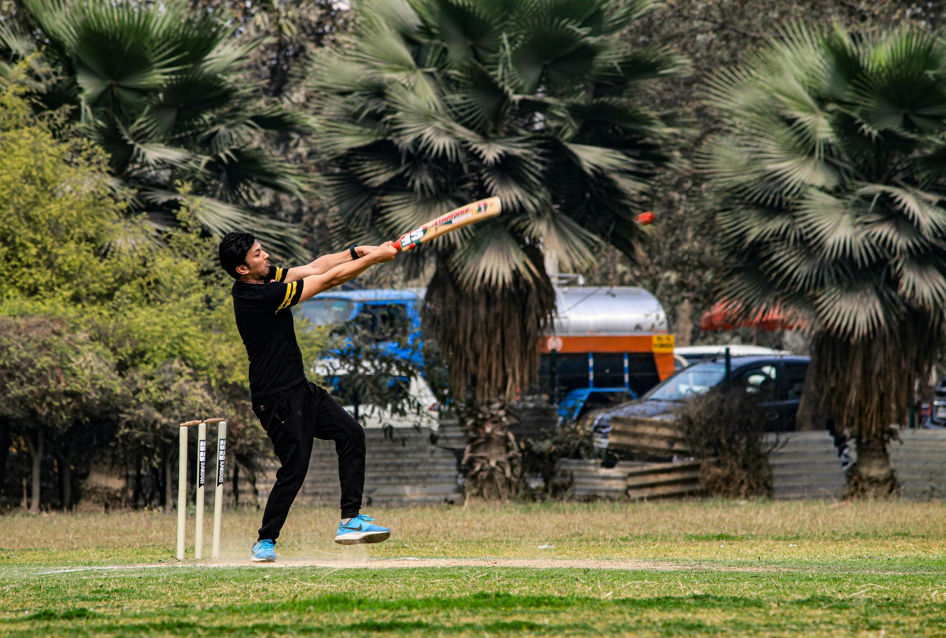 A batter launches a big pull shot during a park cricket match