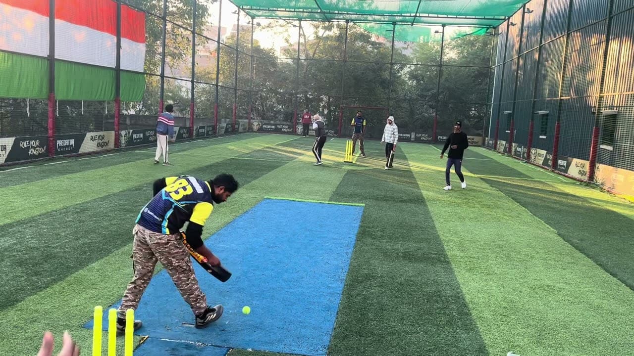 Turf cricket being played under the nets