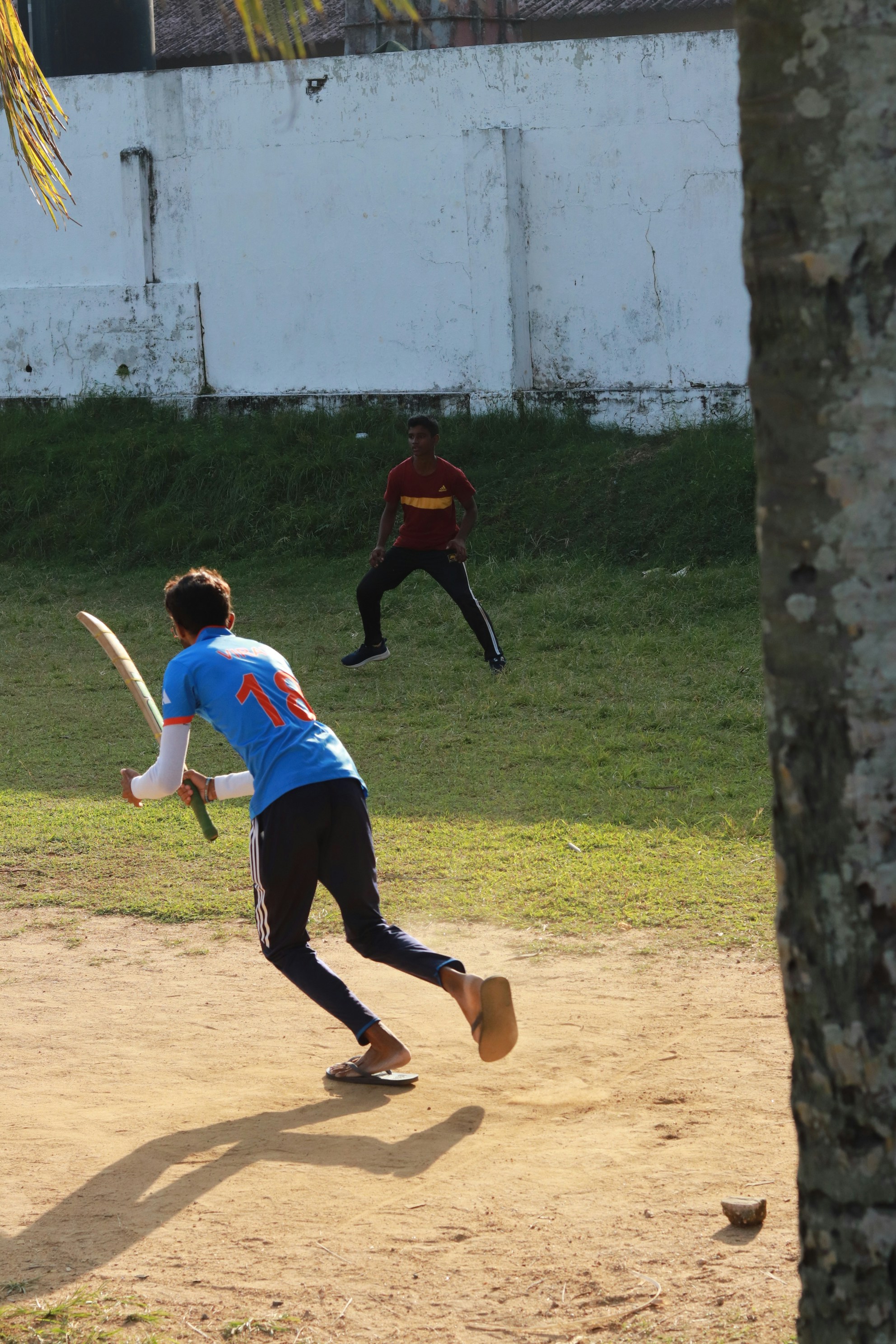 A batter sets off for a run during a street cricket game